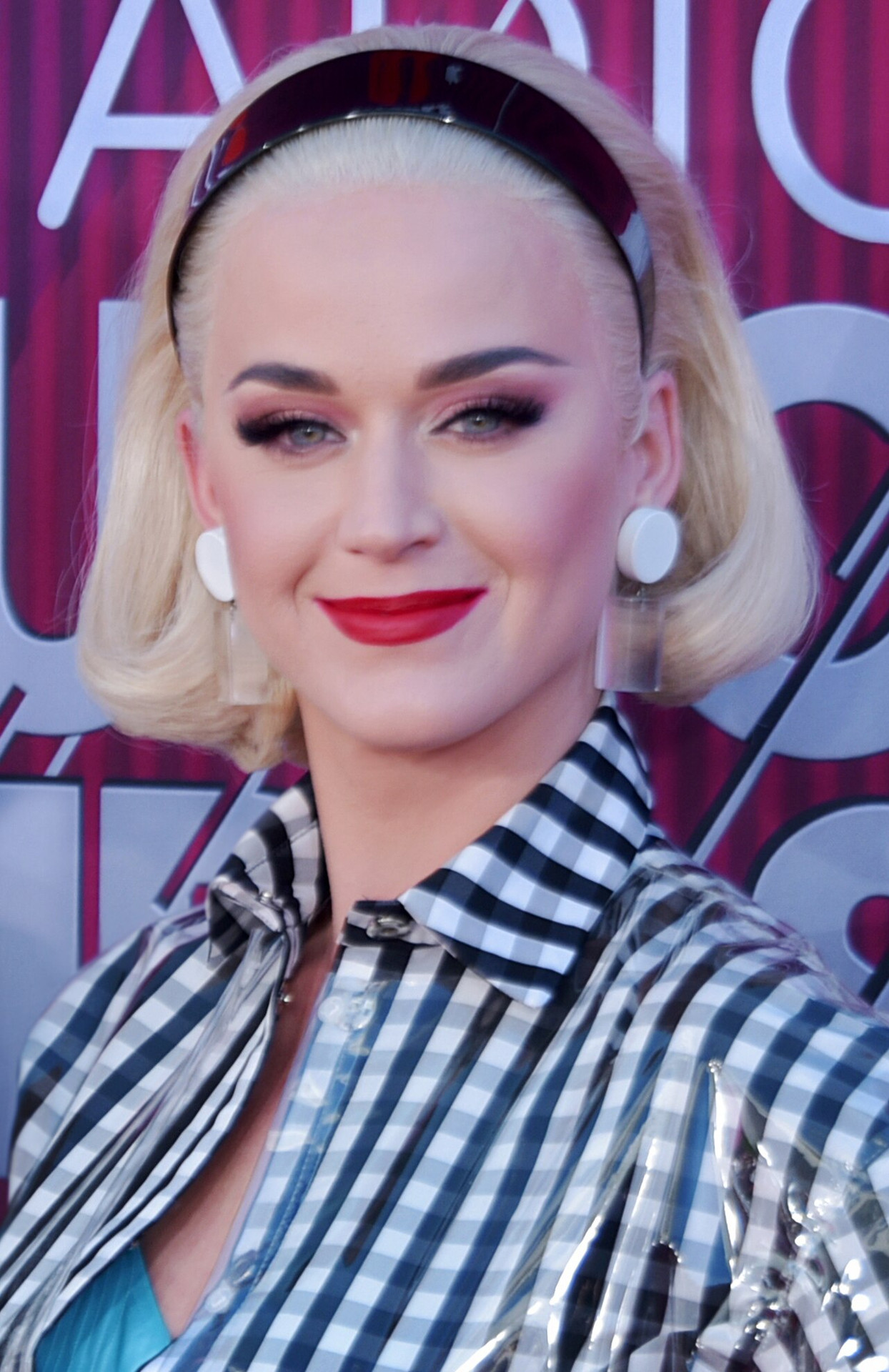 Katy Perry tóc bob bạch kim, son đỏ, mặc áo blouse nơ caro tại một lễ trao giải