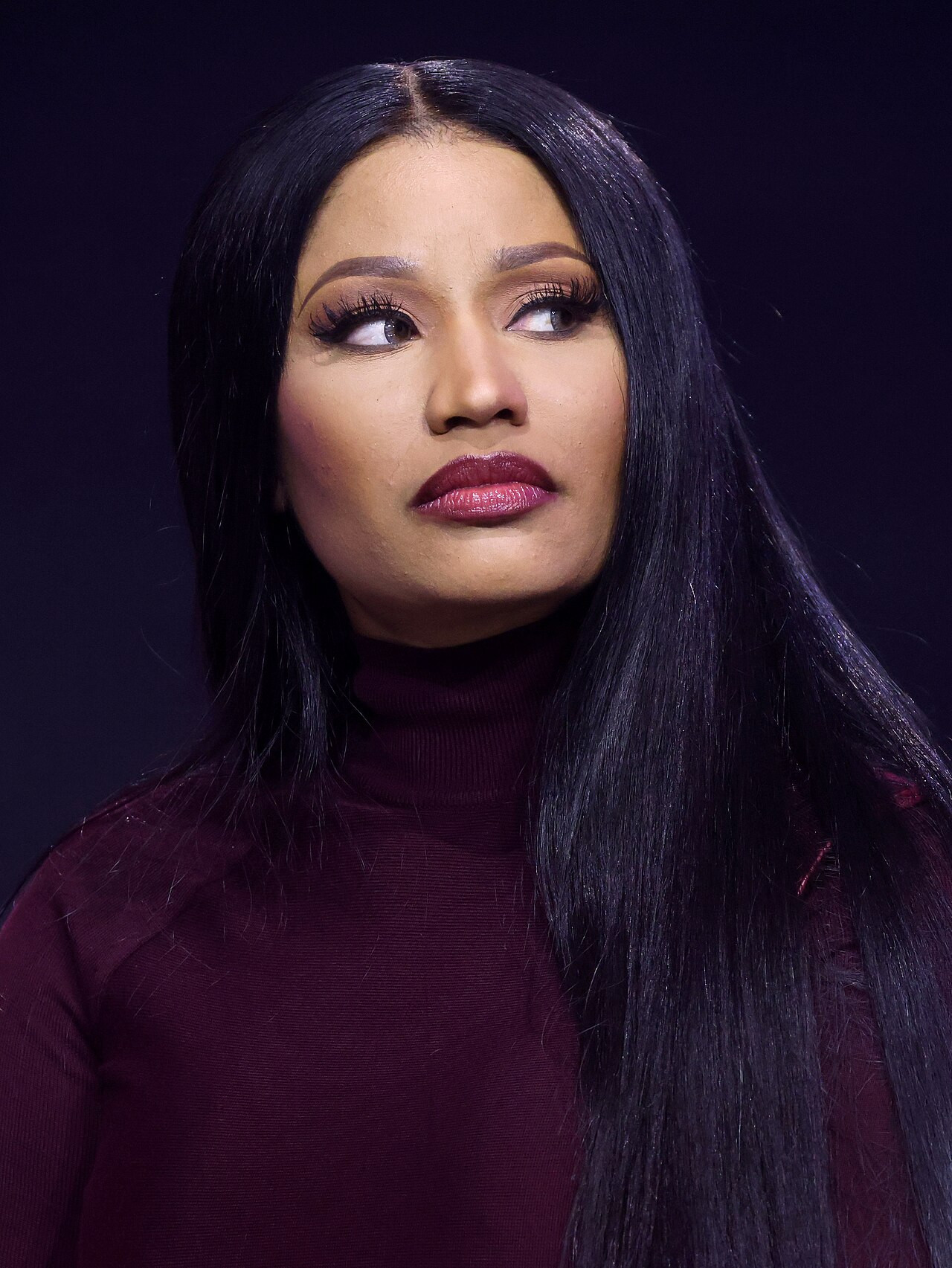 Nicki Minaj con dolcevita bordeaux, capelli neri lisci lunghi e labbra scure